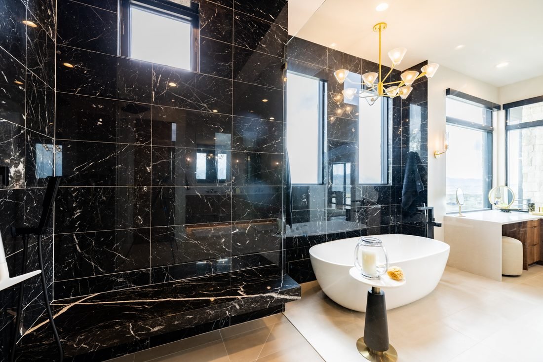 Black marble bathroom with a freestanding tub