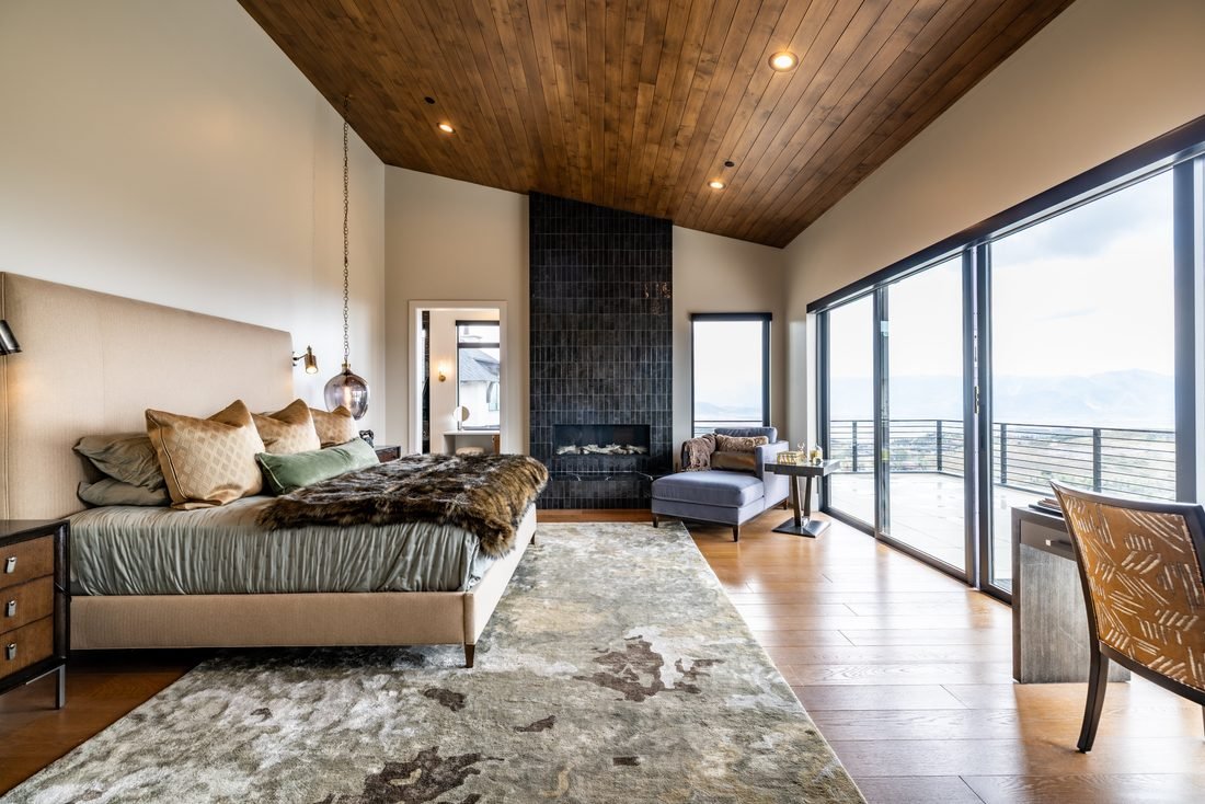 Bedroom with a vaulted wood ceiling and a tiled fireplace