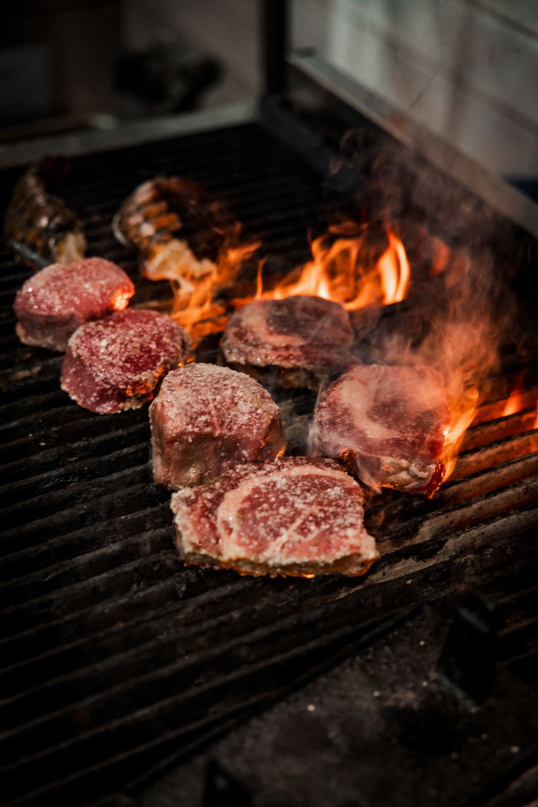 Steaks searing over open flame